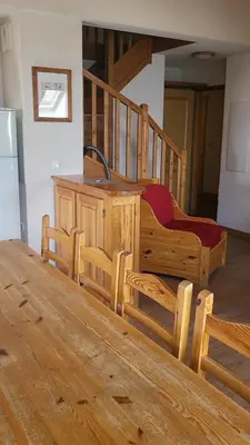 a kitchen with a wooden table and a desk with a refrigerator at Next to the ski lift! *3bed Apt* sleeps 8* Parking* Pool in Saint-Gervais-les-Bains