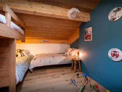 a childs bedroom with blue walls and wooden ceilings at Le Primpiolet - OVO Network in Combloux