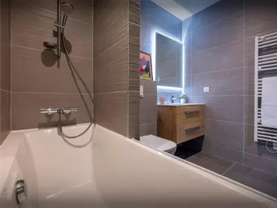 a bathroom with a tub and a toilet and a sink at Le Primpiolet - OVO Network in Combloux