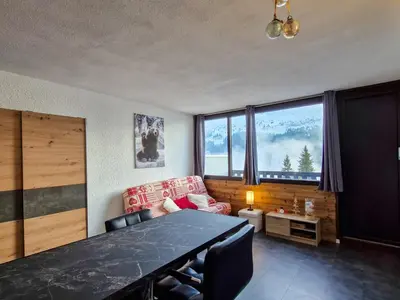 a living room with a table and a couch at Studio rénové à Flaine · Balcon Sud · Idéal pour 4 personnes - FR-1-425-209 in Arâches-la-Frasse