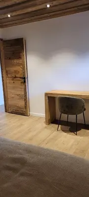 a room with a desk and a chair next to a wall at Les petites chambres St Gervais in Saint-Gervais-les-Bains