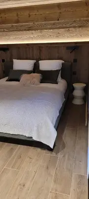 a bedroom with a large bed with a wooden ceiling at Les petites chambres St Gervais in Saint-Gervais-les-Bains