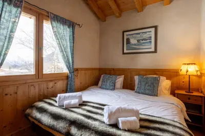 a bedroom with a bed with towels on it at Chalet Melusine - Big Chalet w Spa Pool, Sauna, Huge Terrace, Views & Privacy! in Argentiere