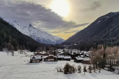 a village in the snow with mountains in the background at Chalet Melusine - Big Chalet w Spa Pool, Sauna, Huge Terrace, Views & Privacy! in Argentiere