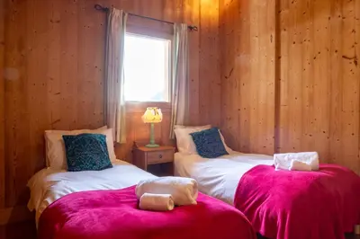 a bedroom with two beds with a teddy bear sitting on them at Chalet Melusine - Big Chalet w Spa Pool, Sauna, Huge Terrace, Views & Privacy! in Argentiere