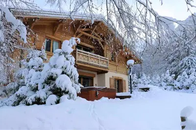 a house covered in snow in front at Chalet Melusine - Big Chalet w Spa Pool, Sauna, Huge Terrace, Views & Privacy! in Argentiere