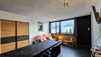 a living room with a table and a couch at Résidence Gemeaux - Studio rénové · Centre station · Balcon MAE-0491 in Magland