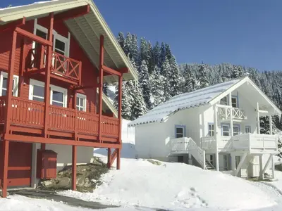 a home with a red and white house in the snow at Chalet lumineux à Flaine avec garage et grand salon - FR-1-425-210 in Arâches-la-Frasse