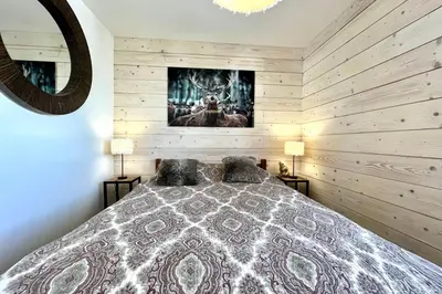a bedroom with a bed and two lamps and a mirror at Le Balcon des Princesses in Demi-Quartier