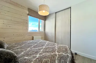 a bedroom with a large bed and a window at Le Balcon des Princesses in Demi-Quartier
