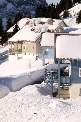 a snow covered house with a bench in the snow at Résidence Hameau - Chalet lumineux · Poêle à bois · WIFI gratuit et illimité · Garage MAE-1691 in Magland
