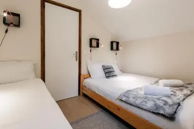 a bedroom with two beds and a mirror at Les Chamois - Duplex - Vue magnifique in Chamonix-Mont-Blanc