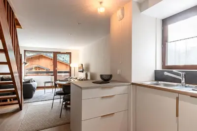 a kitchen with a sink and a table in a room at Les Chamois - Duplex - Vue magnifique in Chamonix-Mont-Blanc