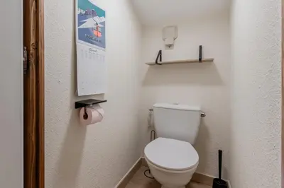 a bathroom with a white toilet in a room at Les Chamois - Duplex - Vue magnifique in Chamonix-Mont-Blanc