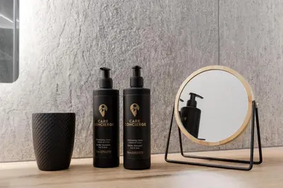 two bottles of hair products next to a mirror at Les Chamois - Duplex - Vue magnifique in Chamonix-Mont-Blanc