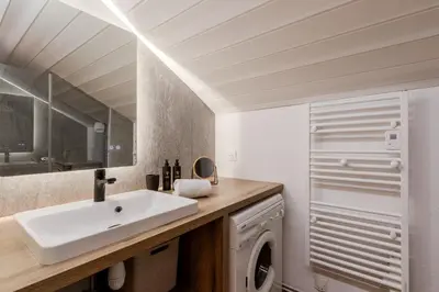 a bathroom with a sink and a washing machine at Les Chamois - Duplex - Vue magnifique in Chamonix-Mont-Blanc