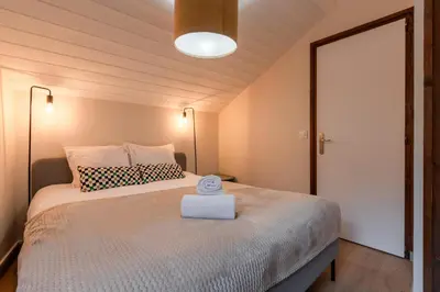a bedroom with a large bed with a white blanket at Les Chamois - Duplex - Vue magnifique in Chamonix-Mont-Blanc
