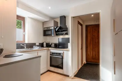 a kitchen with white cabinets and a stove top oven at Les Chamois - Duplex - Vue magnifique in Chamonix-Mont-Blanc