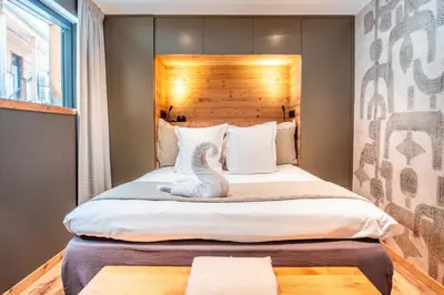 a bedroom with a bed with a white cat sitting on it at Chalet Sia - Contemporain - Sauna prive in Chamonix-Mont-Blanc