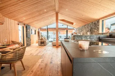 an open kitchen with a counter and a living room at Chalet Sia - Contemporain - Sauna prive in Chamonix-Mont-Blanc