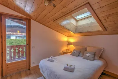 a bedroom with a large bed with a skylight at Appartement Denali - Welkeys in Demi-Quartier