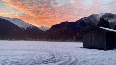 a snow covered field with a hut in the foreground with mountains at Appartement rénové T2, vue montagne in Samoëns