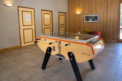 a ping pong table in the middle of a room at Appartement rénové T2, vue montagne in Samoëns