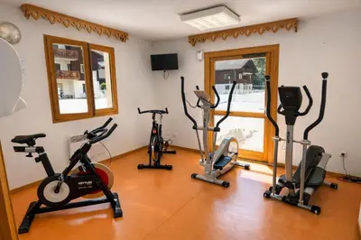 a gym with several exercise bikes in a room at Appartement rénové T2, vue montagne in Samoëns