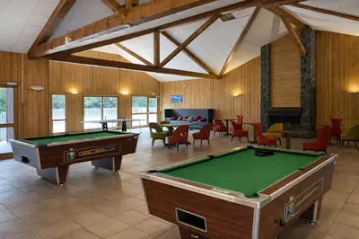a large room with a pool table and chairs at Appartement rénové T2, vue montagne in Samoëns