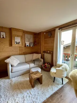 a living room with a white couch and a table at Très bel appartement avec parking gratuit in Megève