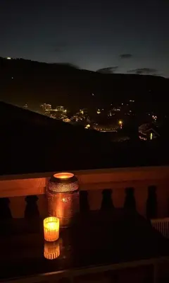 a couple of candles sitting on a table at night at Très bel appartement avec parking gratuit in Megève