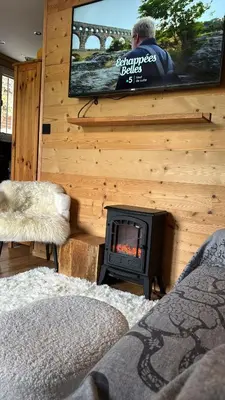 a living room with a fireplace and a tv at Très bel appartement avec parking gratuit in Megève