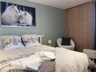 a bedroom with a bed and a picture of wolves at Renovated flat facing Mont Blanc in Combloux