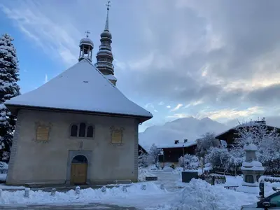 a small church with a snow covered roof at Renovated flat facing Mont Blanc in Combloux