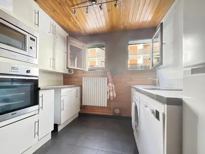a kitchen with white cabinets and a wooden ceiling at 3 Pièces 6/8 Pers centre Carroz (AA111) in Les Carroz d'Araches