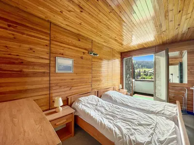 a bedroom with two beds and a wooden wall at 3 Pièces 6/8 Pers centre Carroz (AA111) in Les Carroz d'Araches