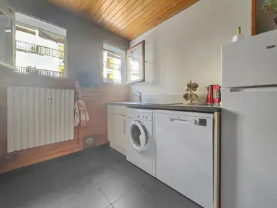 a kitchen with a washing machine and a refrigerator at 3 Pièces 6/8 Pers centre Carroz (AA111) in Les Carroz d'Araches