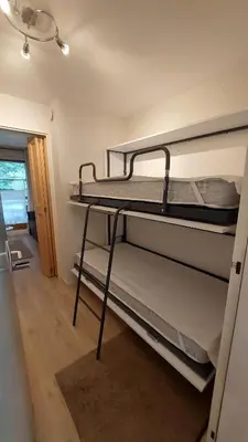 two bunk beds in a room with a hallway at Studio au pied des remontées/wifi/smart TV/parking in Les Contamines-Montjoie