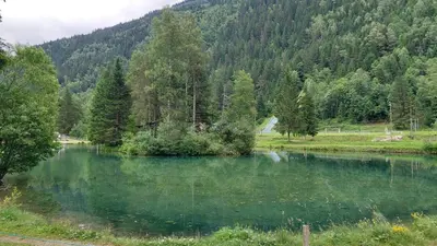 a lake in the middle of a field with trees at Studio au pied des remontées/wifi/smart TV/parking in Les Contamines-Montjoie