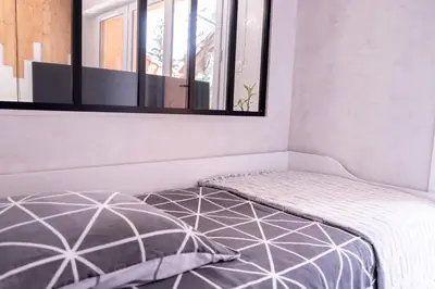 a bedroom with a bed with a mirror on the wall at Studio cabine Au Loup Blanc avec vue Mont Blanc in Saint-Gervais-les-Bains