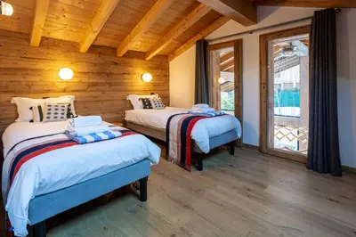 two beds in a room with wooden walls at Chalet Gloribel in Chamonix-Mont-Blanc
