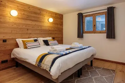 a bedroom with a large bed with wooden walls at Chalet Gloribel in Chamonix-Mont-Blanc