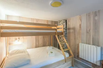 a bedroom with two bunk beds and a ladder at Appartement Sous-Bois - Welkeys in Chamonix-Mont-Blanc