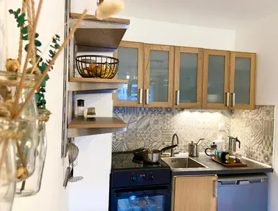 a kitchen with wooden cabinets and a sink and a stove at Le refuge 'Les 4 têtes' - balcon - vue montagne - proche centre & gare in Sallanches