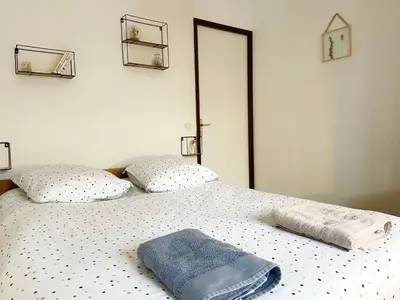 a bed with two pillows and a towel on it at Le refuge 'Les 4 têtes' - balcon - vue montagne - proche centre & gare in Sallanches