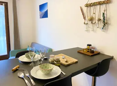 a black table with two plates and glasses on it at Le refuge 'Les 4 têtes' - balcon - vue montagne - proche centre & gare in Sallanches