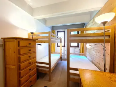 a bunk bed room with two bunk beds and a desk at Appartement confortable · Proche pistes · WIFI gratuit - FR-1-425-211 in Arâches-la-Frasse