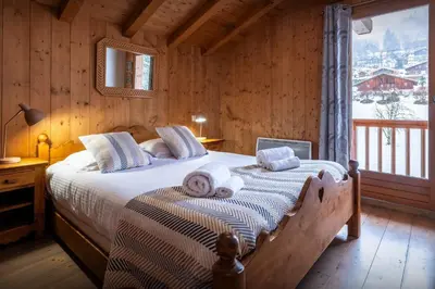 a bedroom with a bed with towels on it at Chalet Timothy - OVO Network in Samoëns