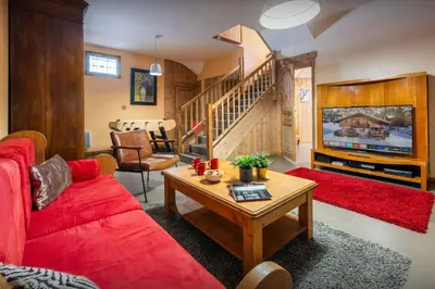 a living room with a red couch and a table at Chalet Timothy - OVO Network in Samoëns