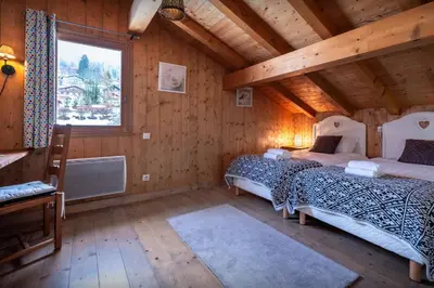 a bedroom with two beds in a wooden cabin at Chalet Timothy - OVO Network in Samoëns